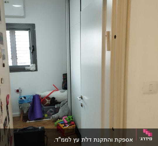 דלת פתוחה לחדר עם צעצועים על הרצפה